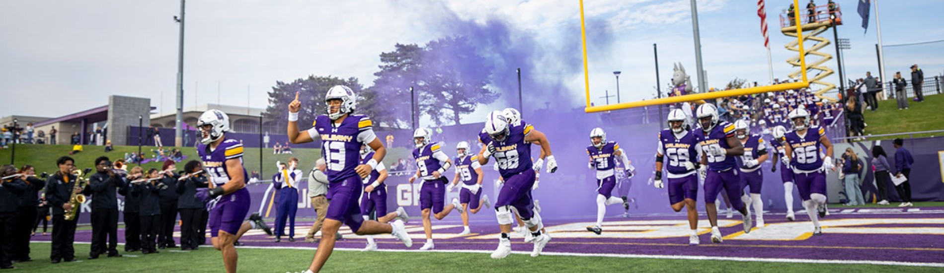 UAlbany football players running on to the field.