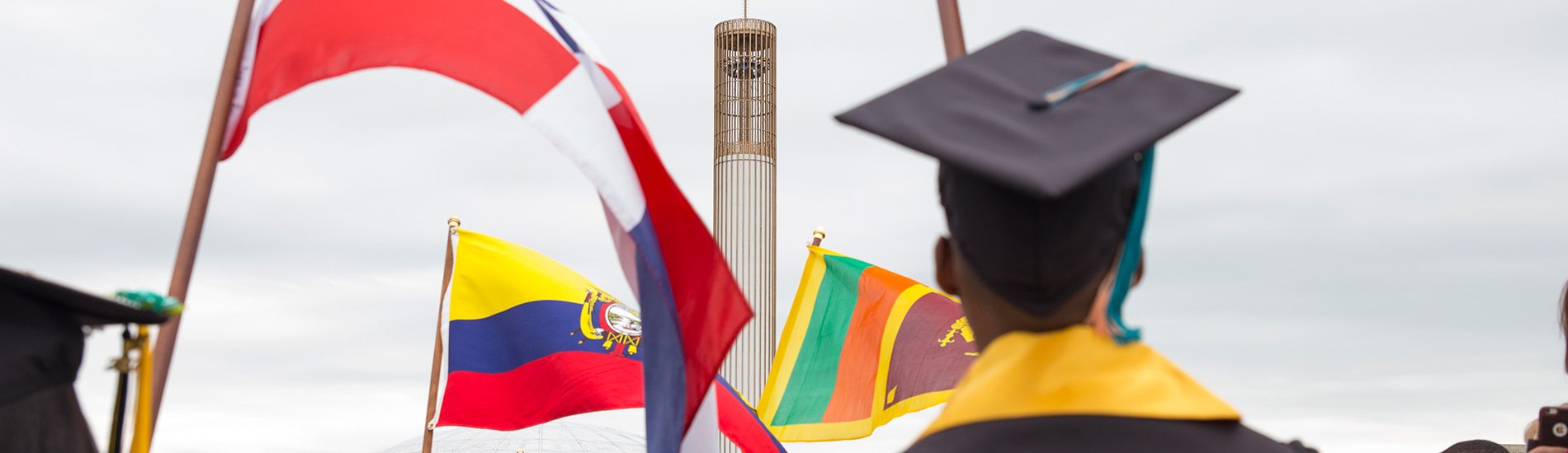 International students carry flags at Commencement.