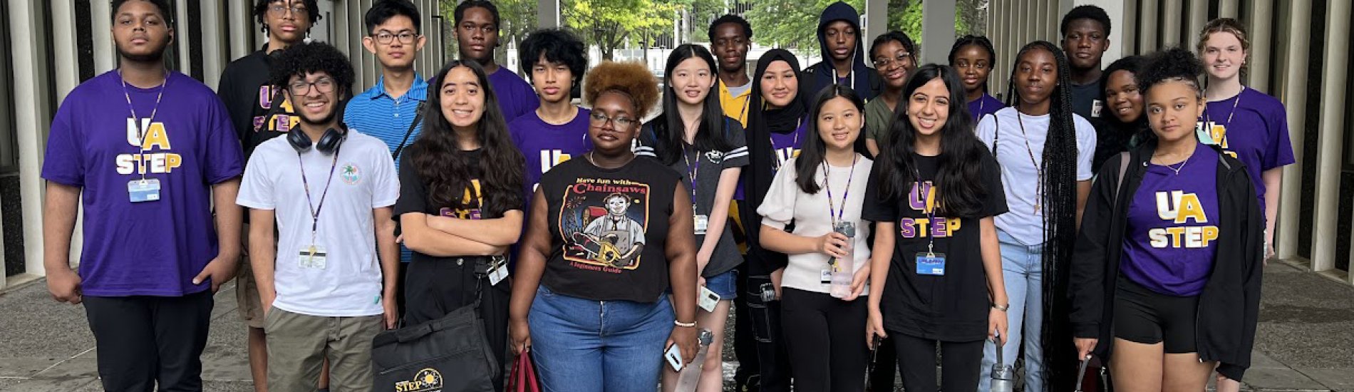 About 20 students participating in UAlbany's Science & Technology Entry Program (STEP) pose for a photo outside on campus.