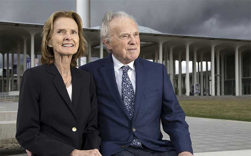 Bonnie Taylor and Daniel Wulff sit near the entry fountain on UAlbany's uptown campus