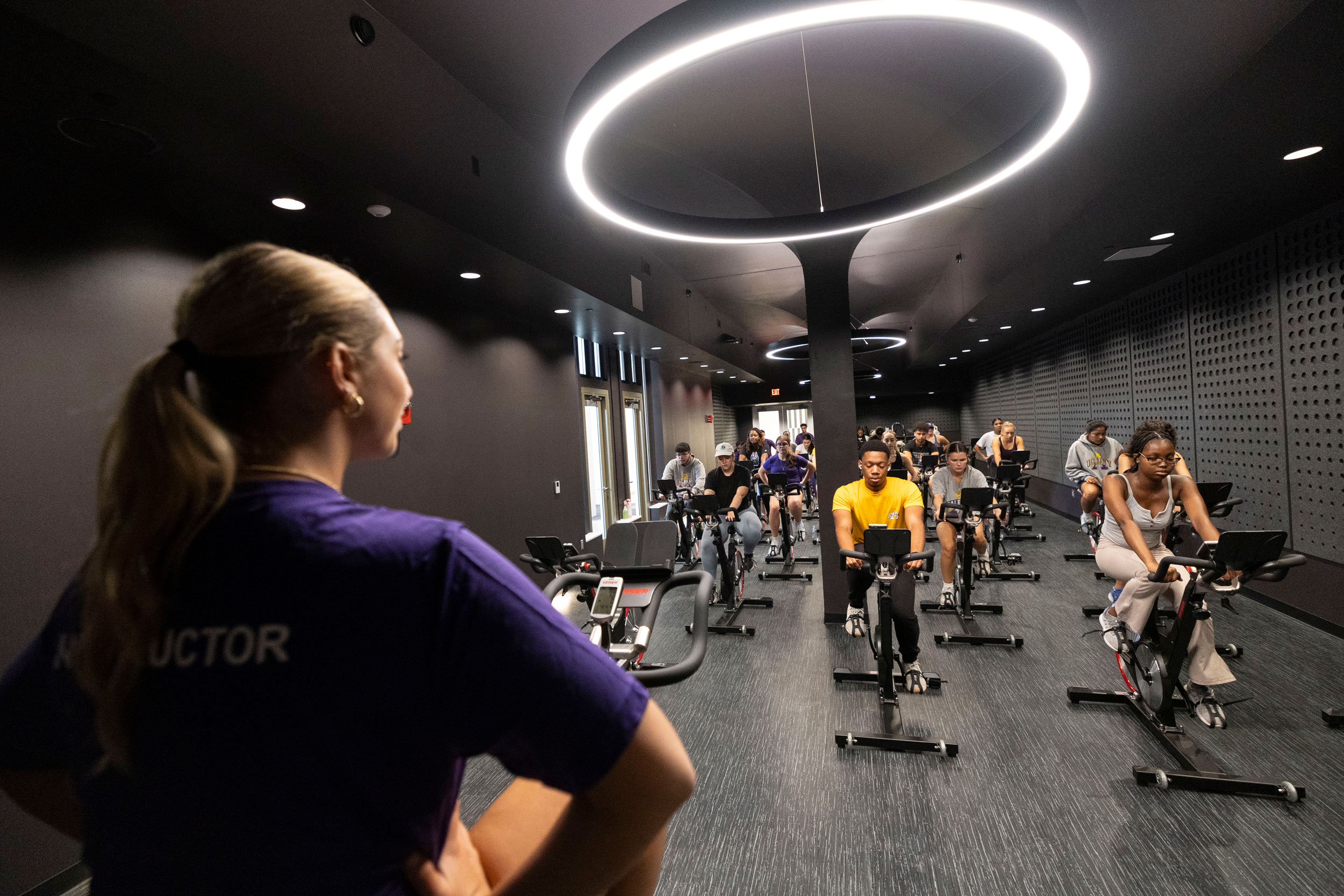 A group exercise instructor leads an indoor cycling class inside The Well at Colonial.
