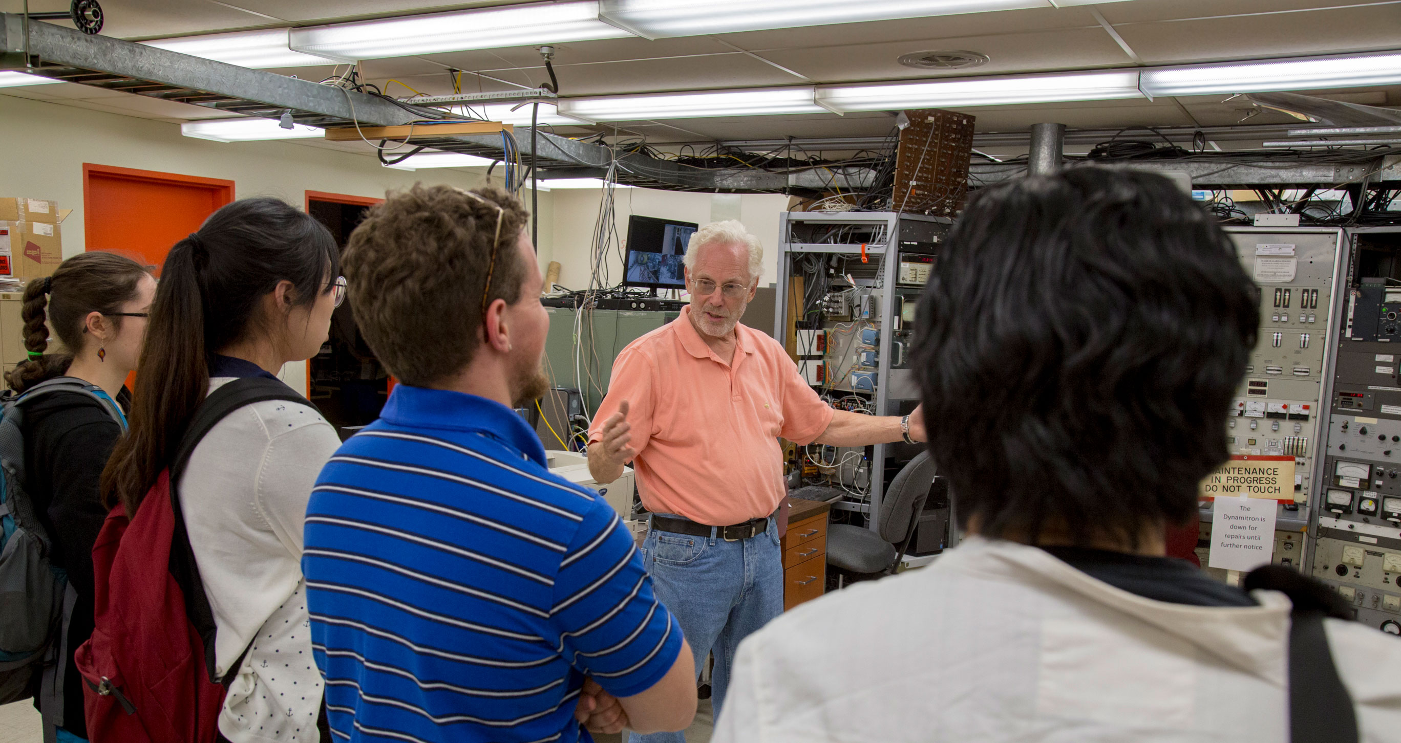 Dr. William Langford gestures as he speaks to a group of students touring the Ion Beam Lab.