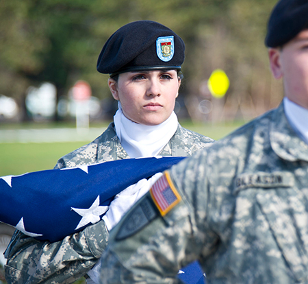 A member of UAlbany's ROTC program holds the American Flag during a Veterans Day Ceremony on Collins Circle.