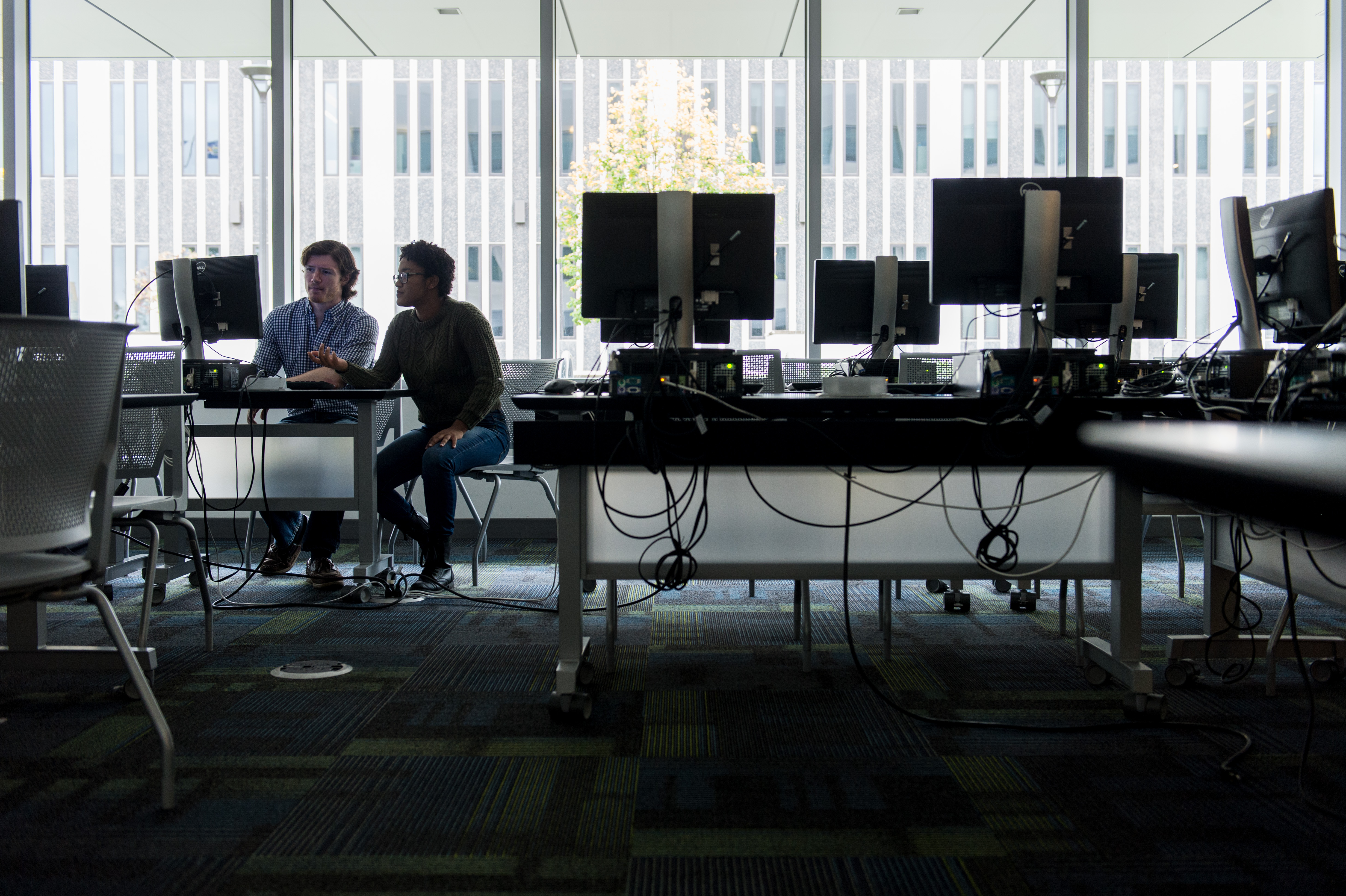 Two students collaborate at a computer at the UAlbany uptown campus.