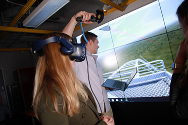 UAlbany graduate research assistant Vanessa Przybylo rides a virtual reality roller coaster in the xCITE Lab.