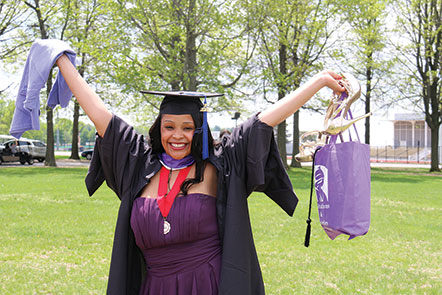 New graduate poses at the GOLD tent