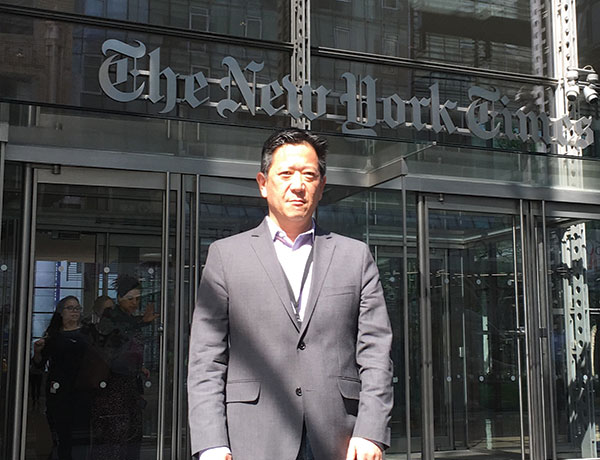 Dean Chang poses for a photo in front of the New York Times building