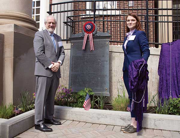 Provost James Stellar and student veteran Crystal Wilson in front of WWI and WWII plaques