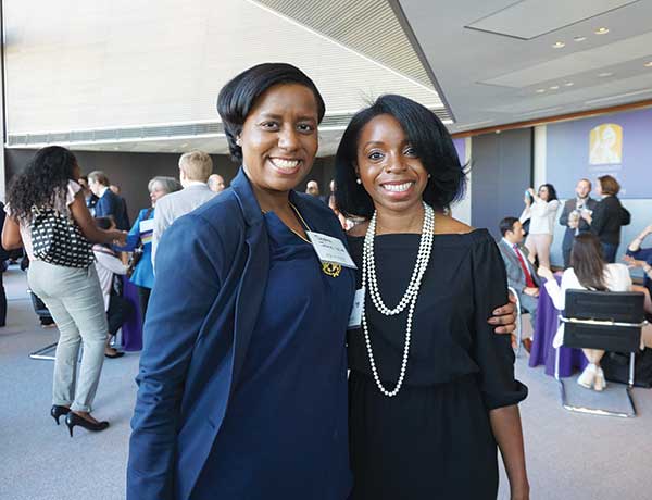 Two alumni pose for a photo at the Hearst Tower reception in New York City