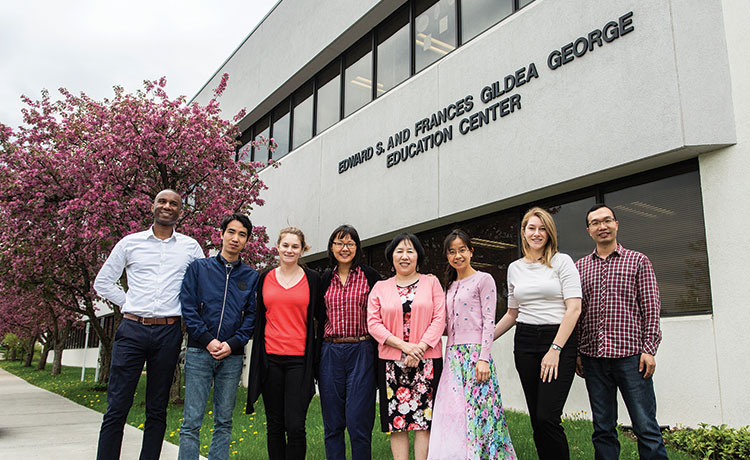 Professor Lin poses for a picture with her grad students in front of the George Education Center