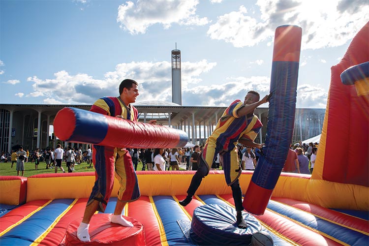 Students battle on colorful inflatable arena in front of the Podium.