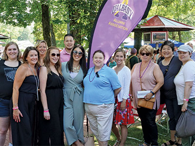 More alumni in front of the UAlbany Alumni Association banner at the race track.