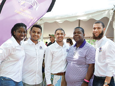 A group of alumni next to the UAlbany Alumni Association banner.