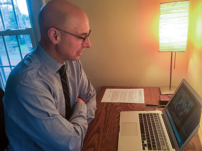 Chris Pastore moderates a Zoom meeting on his laptop.