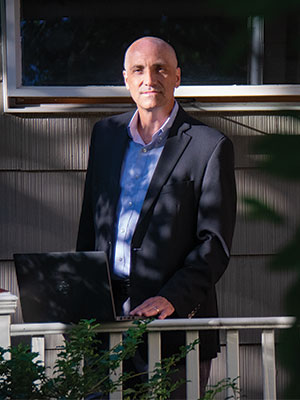 Chris Moore stands in front of his house