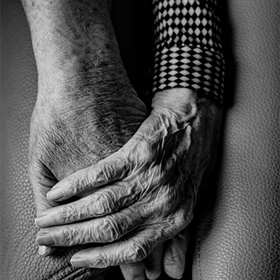 Wrinkled hands holding each other