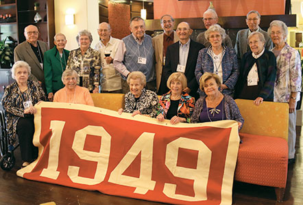 Class of 1949 poses with a banner at their 65th reunion last fall