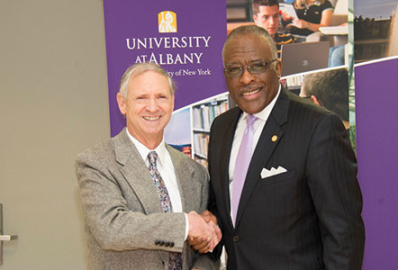 Michael Sattinger shakes hands with UAlbany President Robert J. Jones