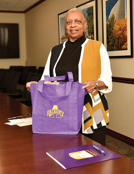 Adell Smith poses for a photo wtih a UAlbany tote bag