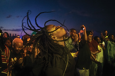 African american woman with braids dancing at an Afropunk musical festival