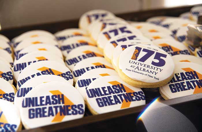 A pile of cookies decorated with Unleash Greatness and 175 University at Albany logo