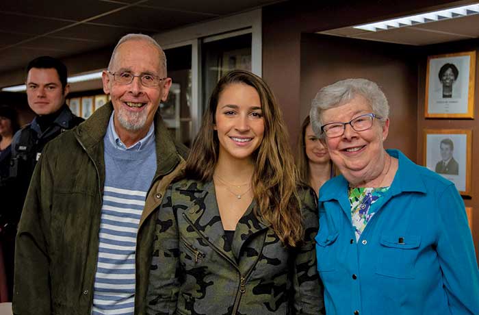 Stu and Judy Madnick and Aly Raisman pose for a photo after an event