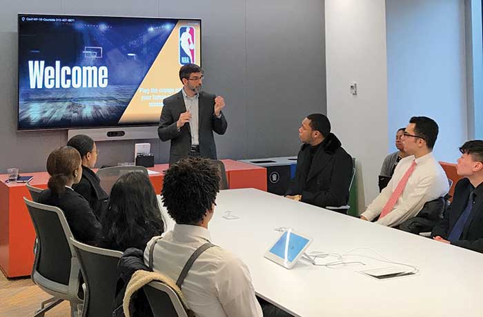 Brennan speaks to a group of students about the NBA in a conference room