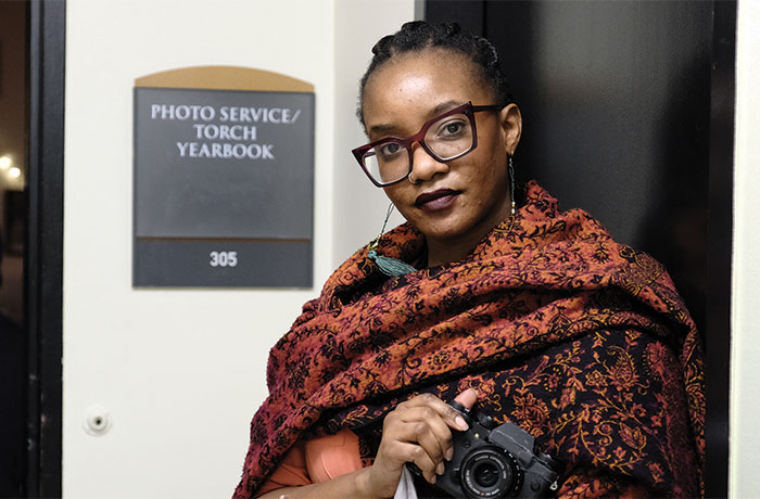 Melissa Elian poses for a photo in front of the Photo Service Tourch Yearbook room at UAlbany