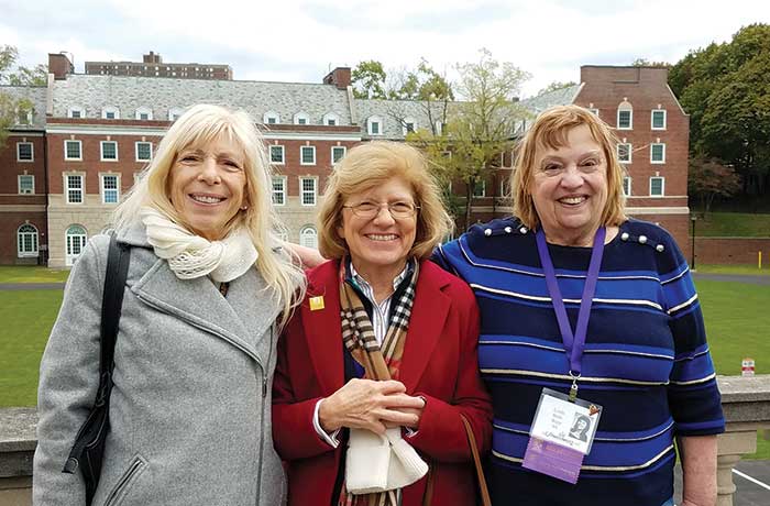 Three members of the class of 1968 pose for a photo on the downtown campus