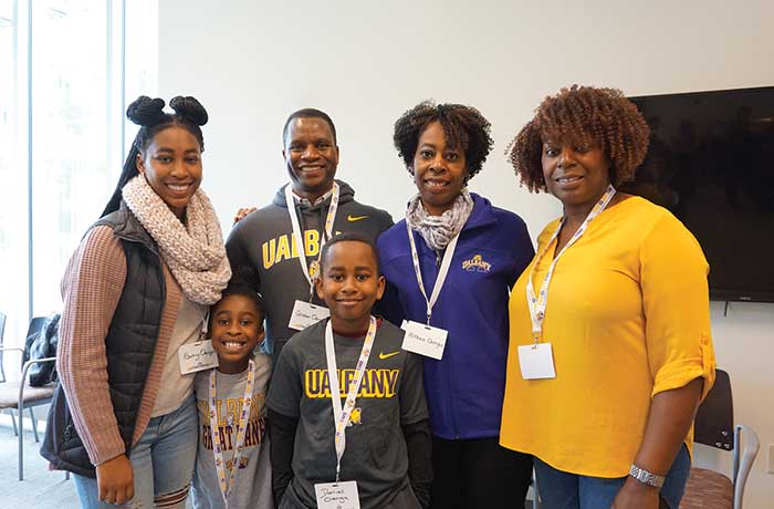 A family poses for a photo in UAlbany gear