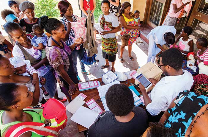 Health workers in Arusha, Tanzania, use tablets to pull up patient records.