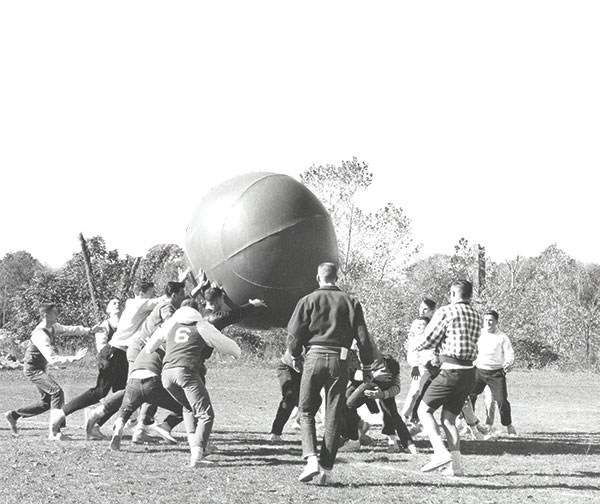 Students play a game with a gigantic basketball outside