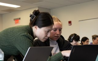 Assistant Professor Zheng Wu reviews environmental data on a student laptop.